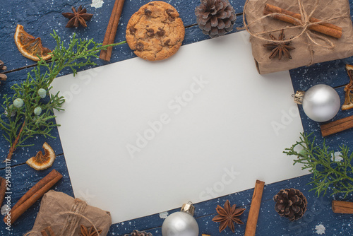 White Christmas card, on New Year's holiday background. Christmas tree branch, cookies. toys. Top view for design.