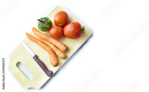 Carrot, Tomato, Eggplant, Knife and wooden cutting board isolated on white background.