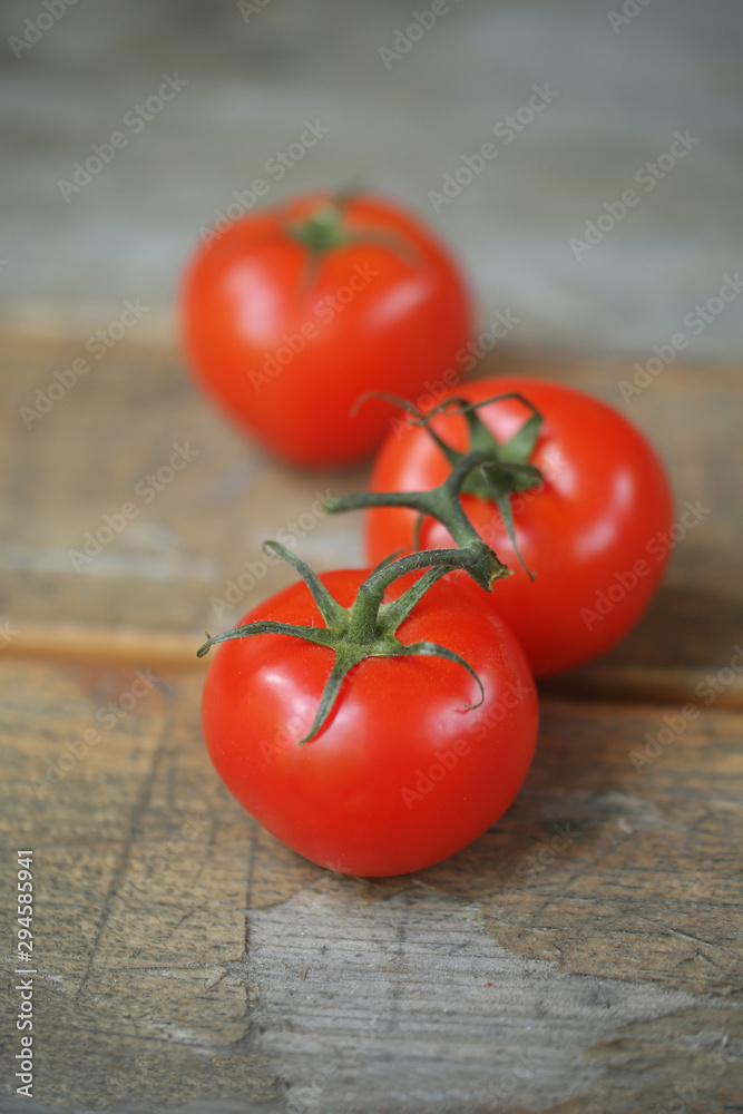 tomatoes on a branch on a wooden background tomatoes on a branch on a wooden background