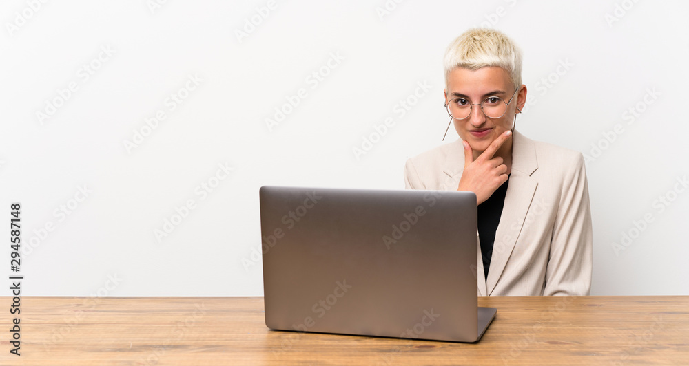 Teenager girl with short hair with a laptop thinking Teenager girl with short hair with a laptop thinking