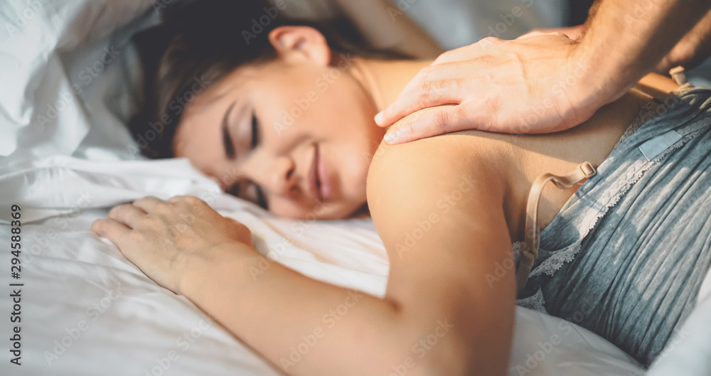 Happy couple having tender moments in the bed - Young romantic lovers intimate massaging and cuddling in the bedroom - People love relationship and relax wellness treatment concept Happy couple having tender moments in the bed - Young romantic lovers intimate massaging and cuddling in the bedroom - People love relationship and relax wellness treatment concept