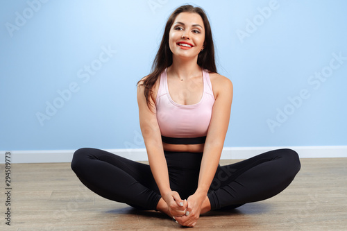 Young beautiful sporty woman doing stretching exercies on a floor