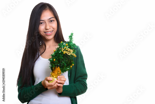 Studio shot of young happy Asian teenage girl smiling while hold