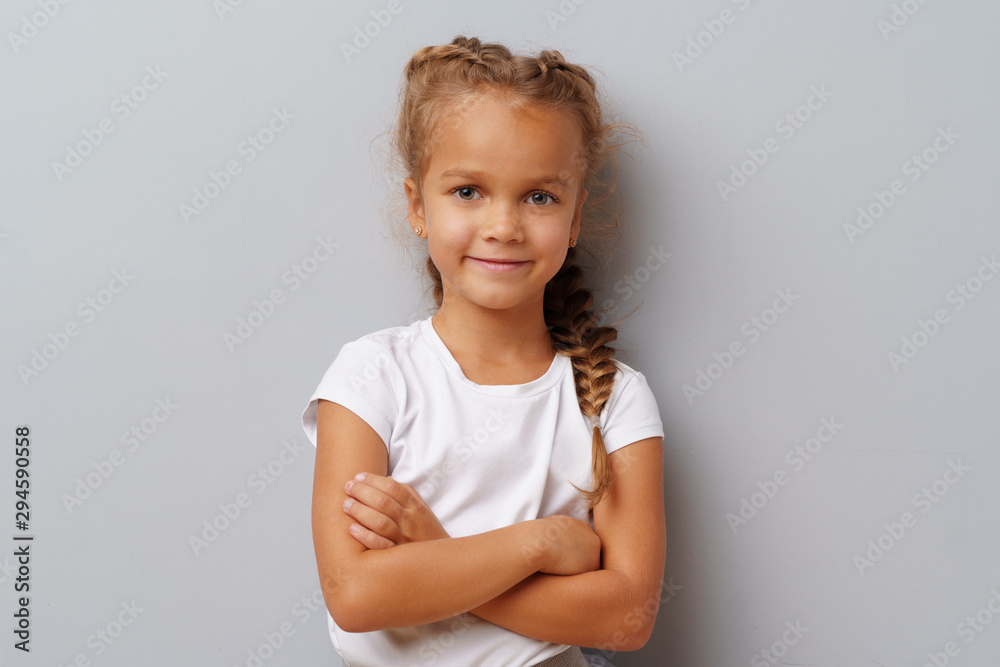 Beautiful little girl posing over a grey background. Beautiful little girl posing over a grey background.
