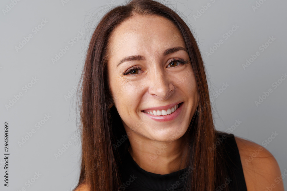 Beautiful woman brunetter posing over a grey background Beautiful woman brunetter posing over a grey background