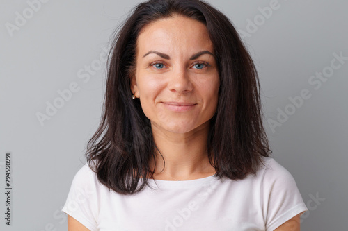 Beautiful woman middle age posing over a grey background