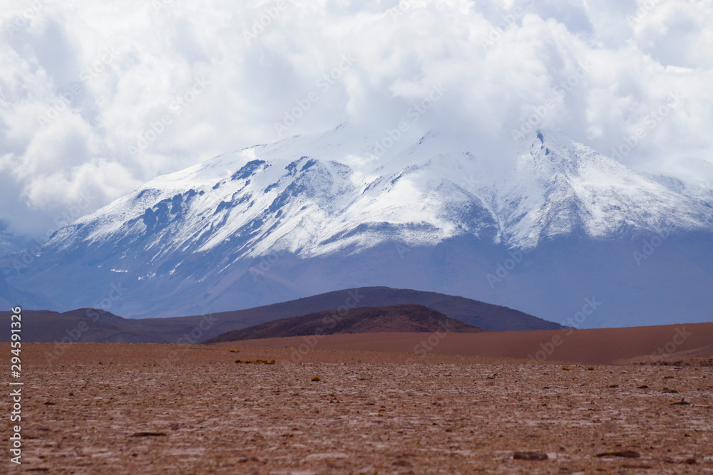 Landscape of the Bolivian highlands. Desert landscape of the Andean plateau of Bolivia with the peaks of the snow-capped volcanoes of the Andes