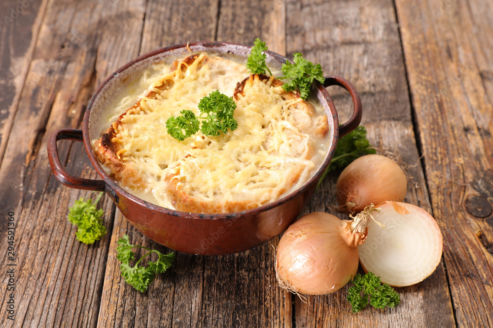 onion soup with bread slice and gruyere on wood background - obrazy, fototapety, plakaty 