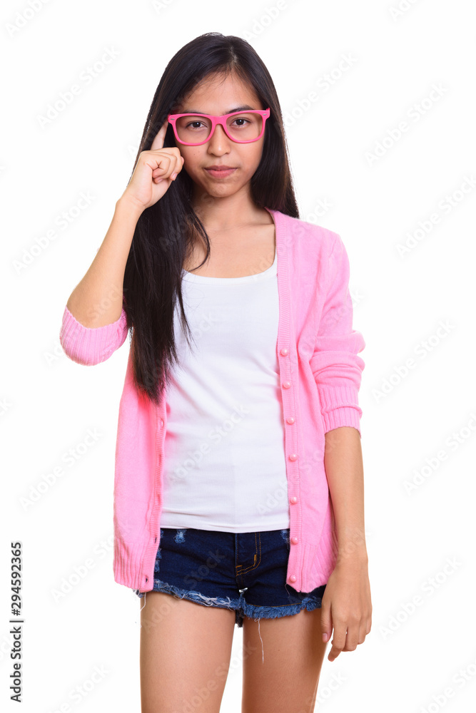 Studio shot of young Asian teenage girl with finger on head Studio shot of young Asian teenage girl with finger on head