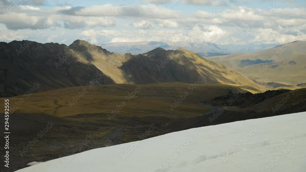 Timelapse of a part of a glacier and mountain valley with rocky mountains. Clouds are floating in the sky and their shadows are moving in the mountains. Timelapse of a part of a glacier and mountain valley with rocky mountains. Clouds are floating in the sky and their shadows are moving in the mountains.