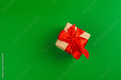 Decorated gift box on a green background, flat lay top view