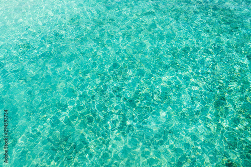 Top view of ripple surface of crystal clear sea with sun reflection. Concept for texture background or wallpaper.