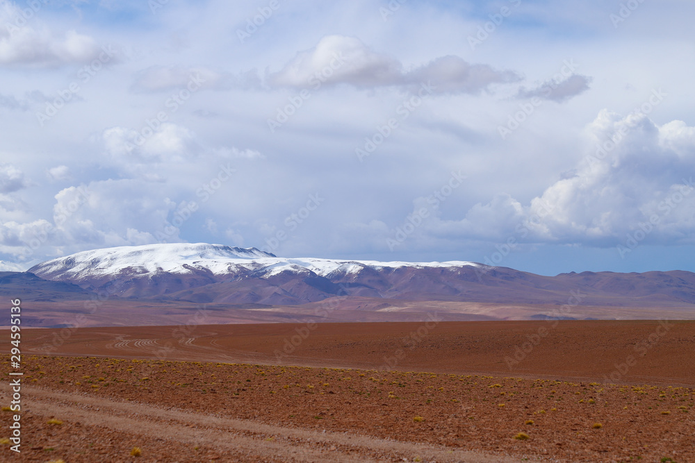 Landscape of the Bolivian highlands. Desert landscape of the Andean plateau of Bolivia with the peaks of the snow-capped volcanoes of the Andes