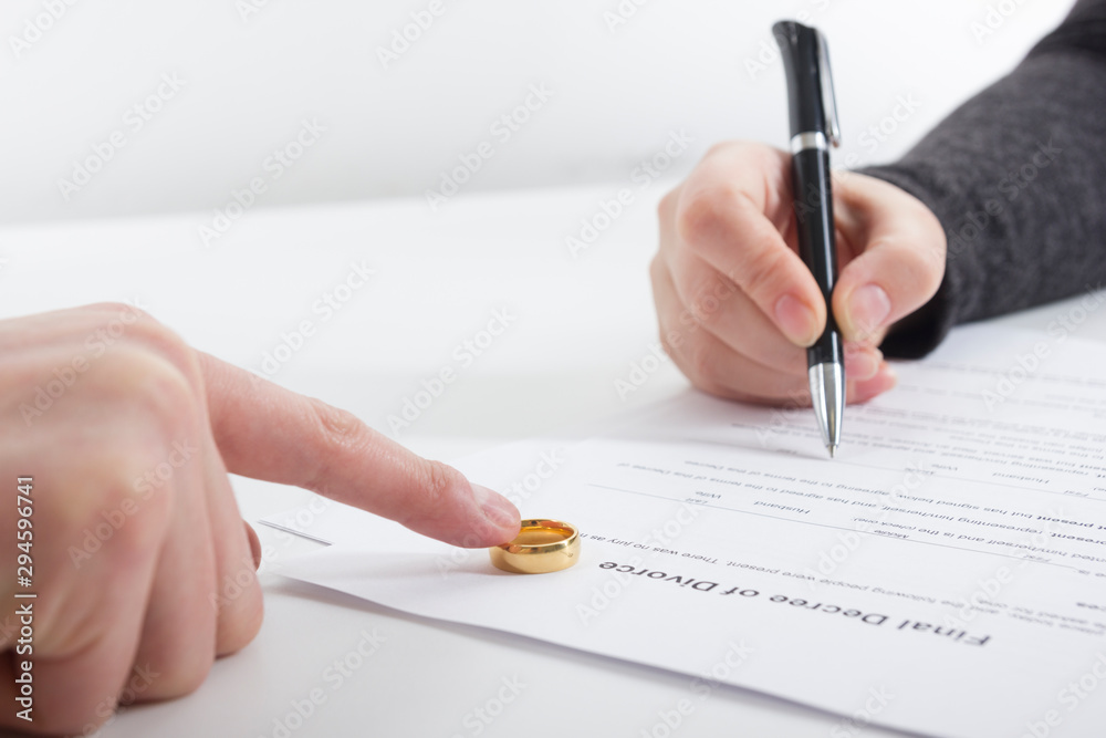 Divorce concept. Hands of wife, husband signing decree of divorce, canceling marriage, legal separation documents. Divorce concept. Hands of wife, husband signing decree of divorce, canceling marriage, legal separation documents.