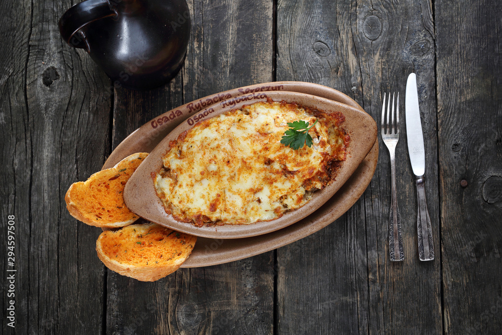 Casserole with potatoes, meat and cheese. Served in a baking dish. Casserole with potatoes, meat and cheese. Served in a baking dish.