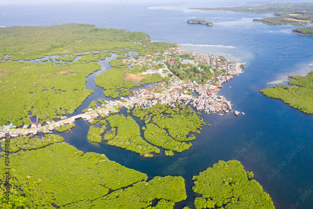 Town on the water and mangroves, top view. Coast of the island of Siargao. Tropical landscape.