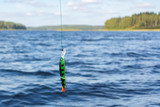 Artificial bait for predatory fish on a fishing line above the water