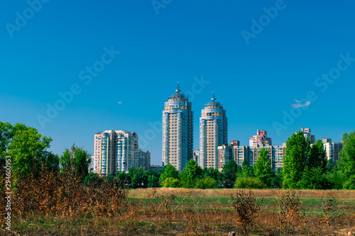 Field with dry yellow grass near the city. Cityscape with dry grass from the heat © Klochkov