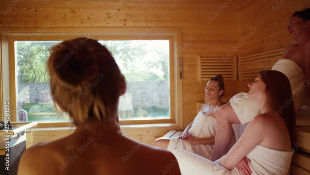 women sitting in a spacious sauna in a luxurious spa - Frauen sitzen gemeinsam in einer geräumigen finnischen Sauna in einem luxuriösem Spa .