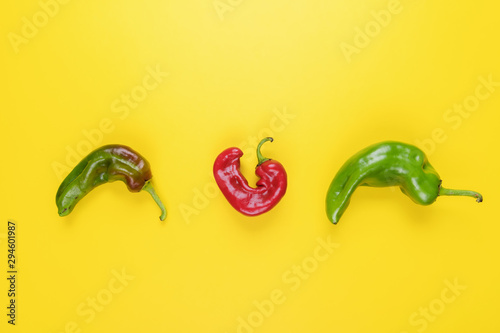 Trendy Ugly red chilli peppers on yellow background, minimal nature style, pop-art, creative food concept photo