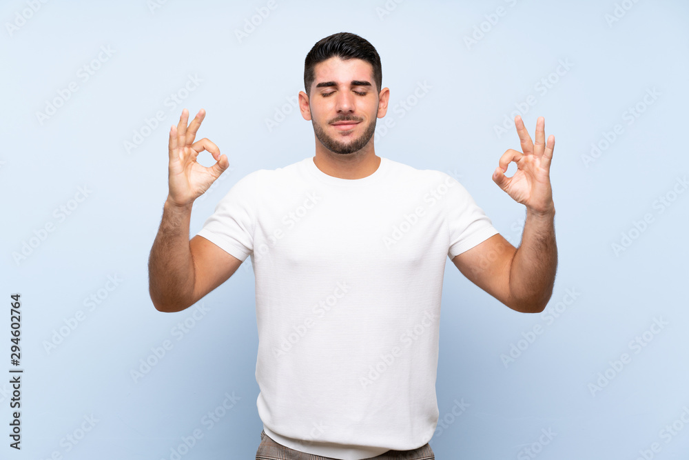 Caucasian handsome man over isolated blue background in zen pose Caucasian handsome man over isolated blue background in zen pose
