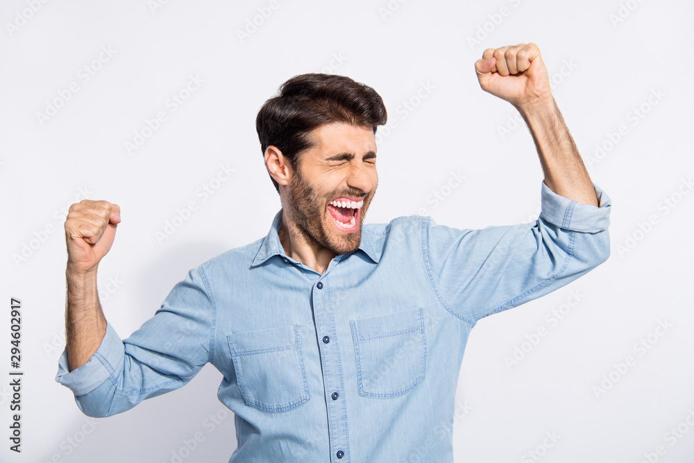 Photo of indian guy celebrating lottery winning raising arms up yelling loudly rejoicing wear casual denim shirt isolated white color background Photo of indian guy celebrating lottery winning raising arms up yelling loudly rejoicing wear casual denim shirt isolated white color background