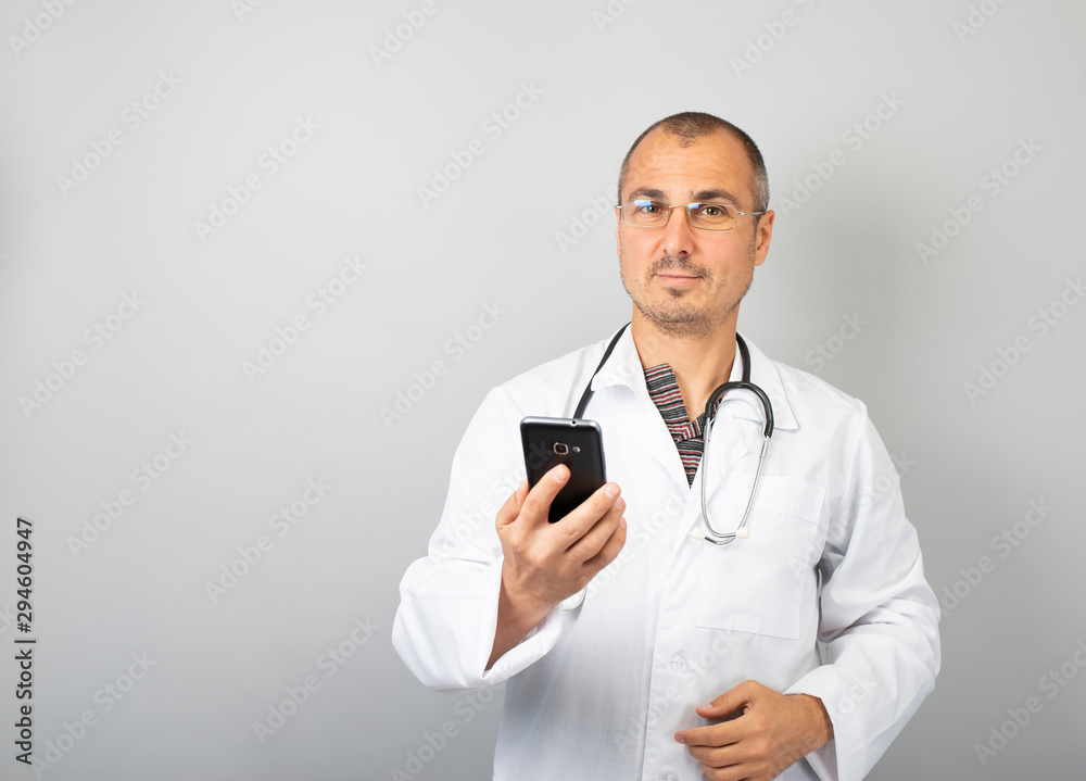 Male doctor is typing a text message on a mobile phone Male doctor is typing a text message on a mobile phone
