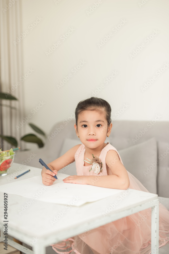 Little girl drawing picture at table with painting tools indoors Little girl drawing picture at table with painting tools indoors