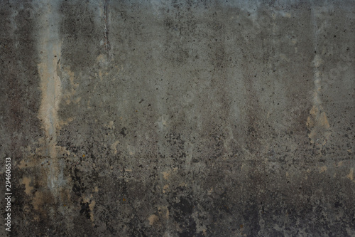 Abstract texture of old grey wall with cracks, scratches and yellow moss. Dark background