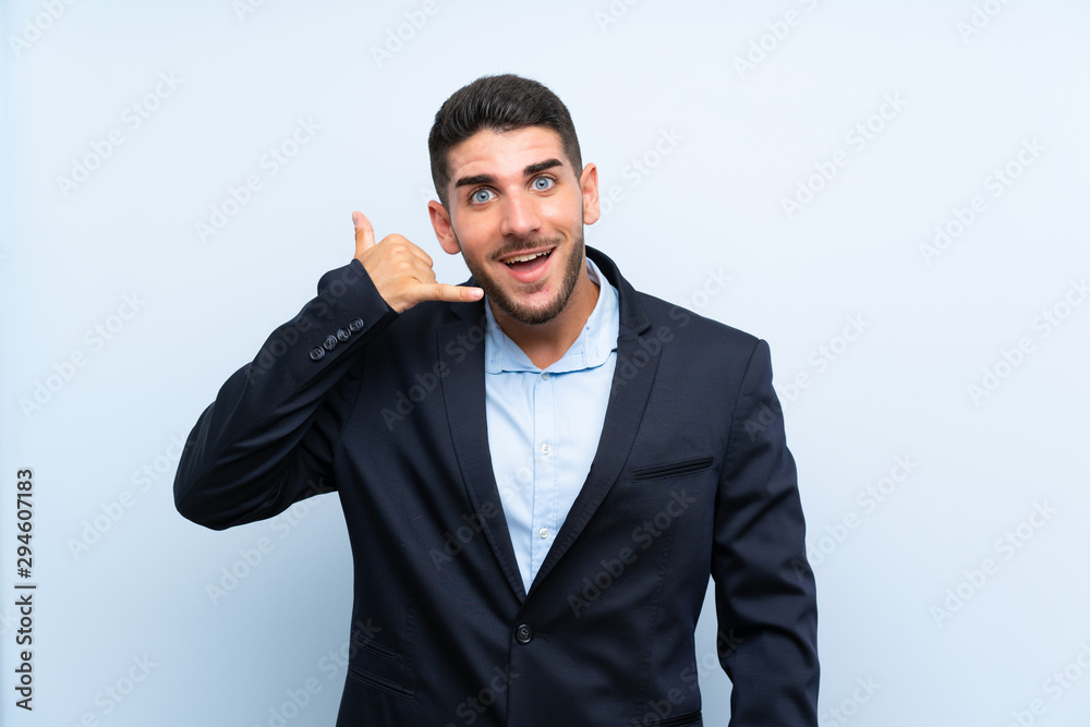 Handsome man over isolated blue background making phone gesture. Call me back sign Handsome man over isolated blue background making phone gesture. Call me back sign