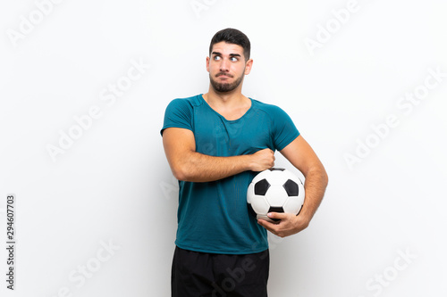 Handsome young football player man over isolated white wall making doubts gesture while lifting the shoulders © luismolinero