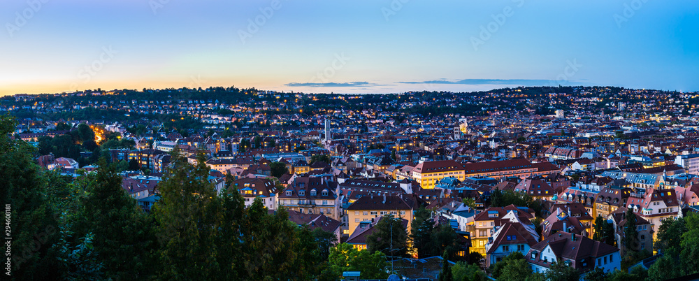 Germany, XXL panorama of sunset sky over urban cityscape of stuttgart city houses and roofs, aerial view from above over illuminated skyline in summertime