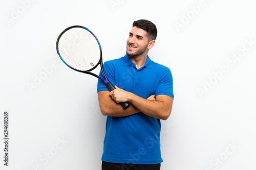Handsome young tennis player man over isolated white wall looking up while smiling © luismolinero