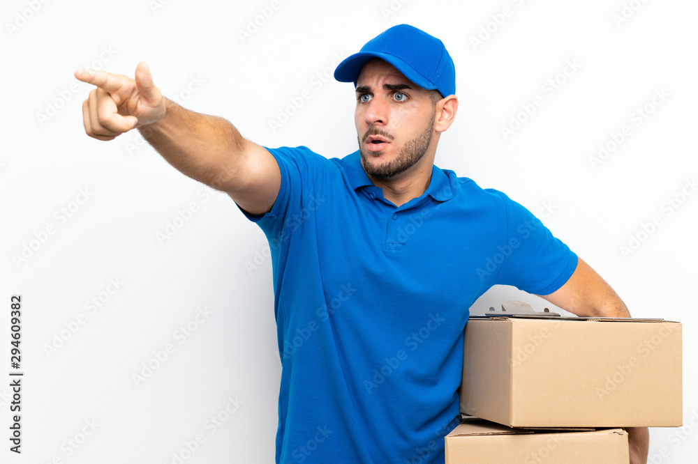 Delivery man over isolated white background pointing away Delivery man over isolated white background pointing away