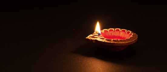 Diwali, Hindu festival of lights celebration. Diya oil lamp against dark background,