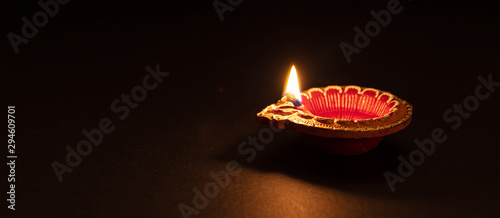 Diwali, Hindu festival of lights celebration. Diya oil lamp against dark background,