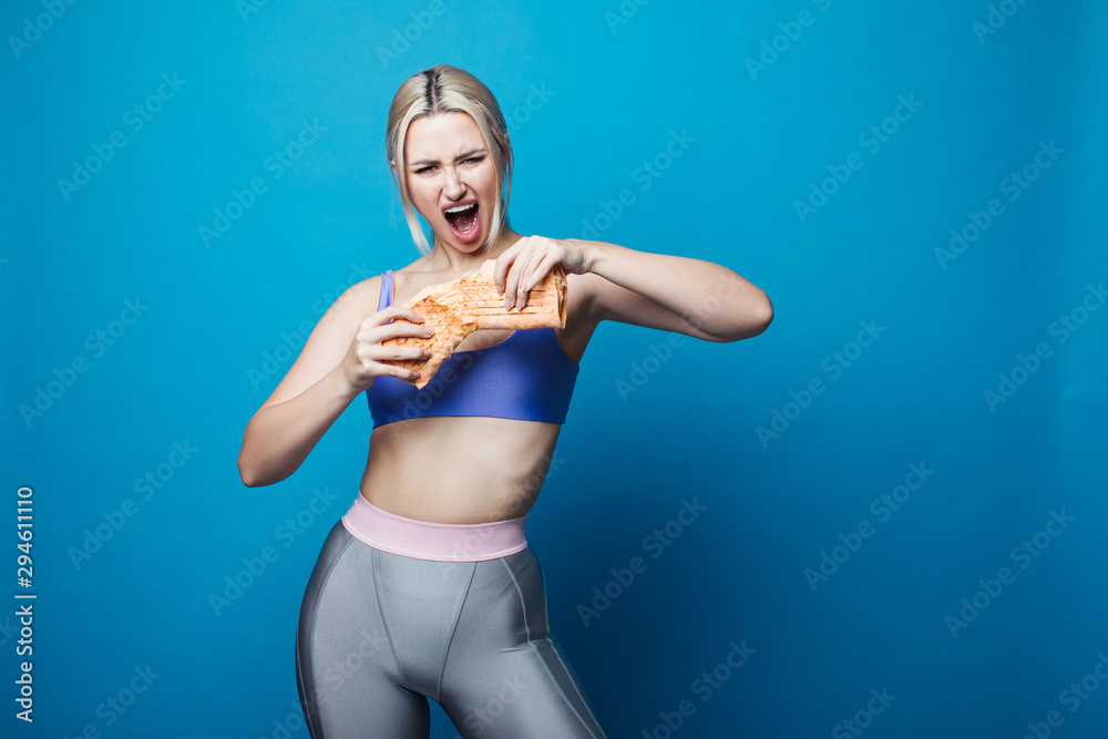 Close up of hungry girl with opened mouth, holding and eating big hamburger. Pretty woman with beautiful hairstyle and red lips. Concept of fast food. Close up of hungry girl with opened mouth, holding and eating big hamburger. Pretty woman with beautiful hairstyle and red lips. Concept of fast food.