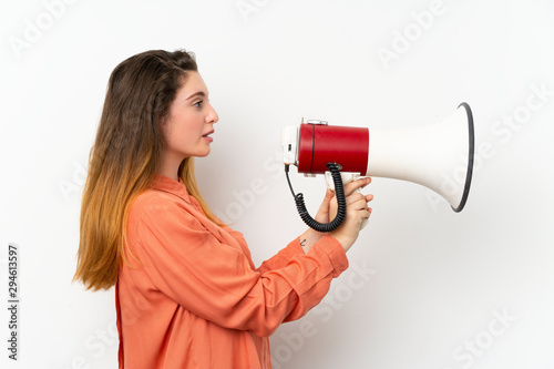 Young brunette girl over isolated white background shouting through a megaphone