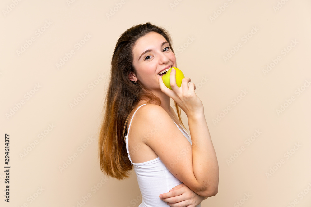 Young brunette girl with an apple over isolated background Young brunette girl with an apple over isolated background