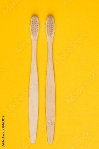 Bamboo toothbrushes on yellow background  top view