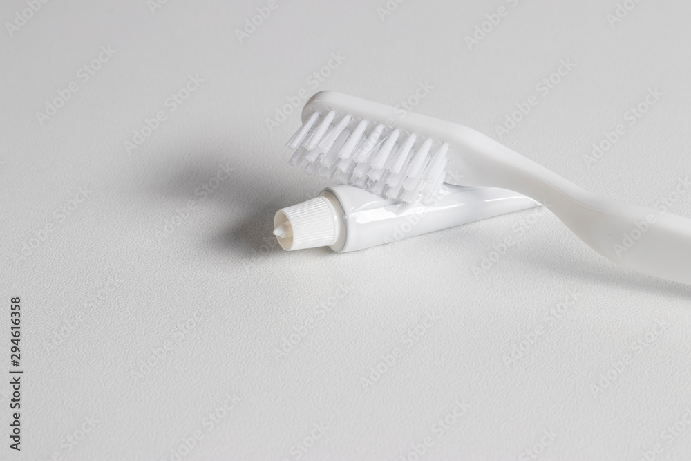 White toothbrush, tube of toothpaste. White toothbrush, tube of toothpaste.
