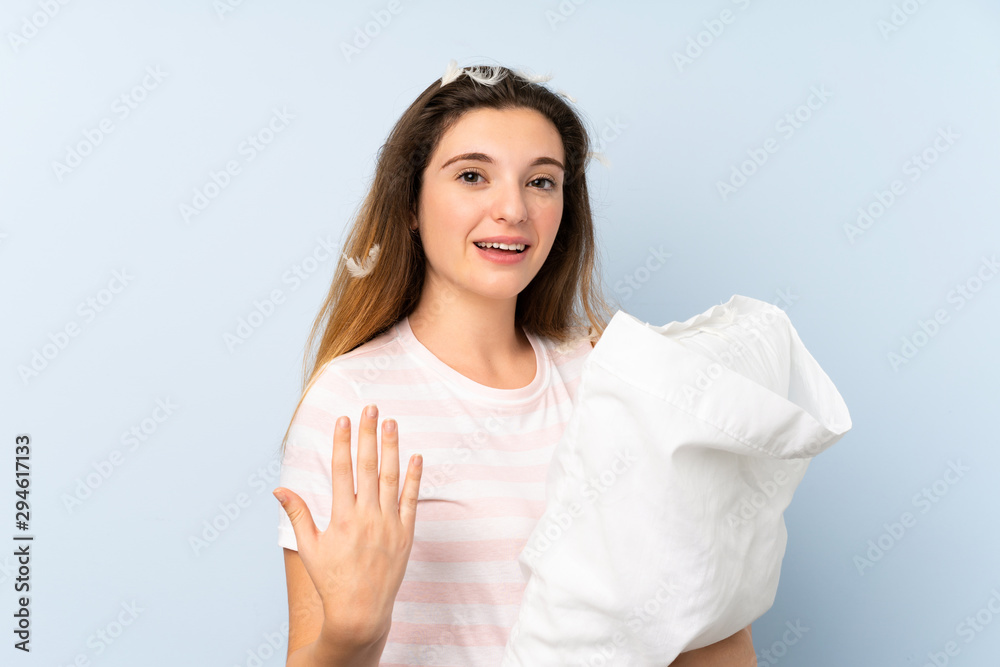 Young woman in pajamas over isolated blue background inviting to come with hand. Happy that you came Young woman in pajamas over isolated blue background inviting to come with hand. Happy that you came
