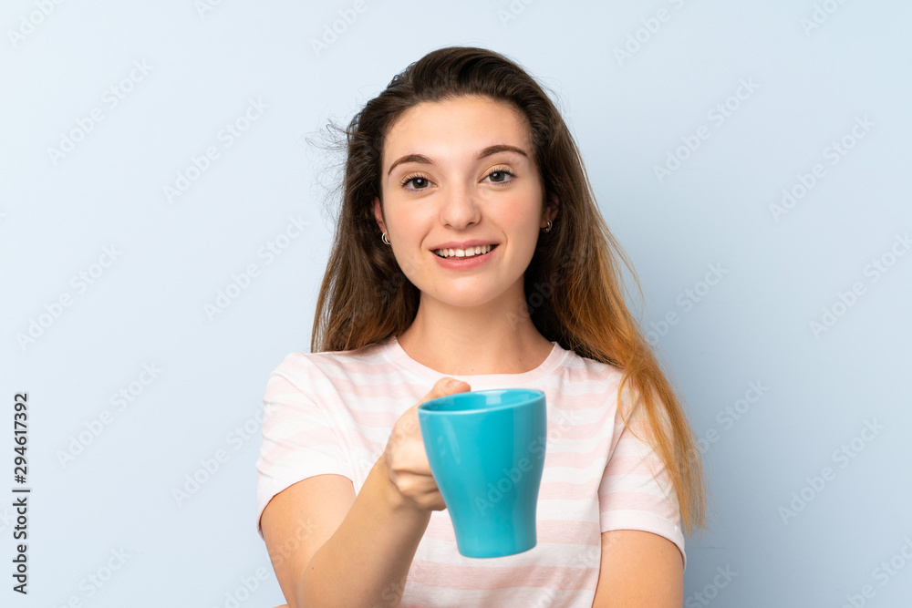 Young brunette girl holding a cup of coffee over isolated background Young brunette girl holding a cup of coffee over isolated background