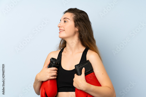 Young brunette girl with boxing gloves over isolated background