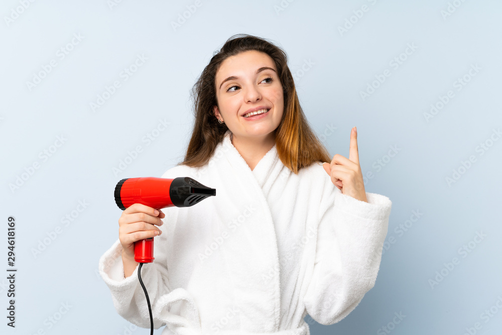 Young woman in a bathrobe with hair hairdryer intending to realizes the solution while lifting a finger up Young woman in a bathrobe with hair hairdryer intending to realizes the solution while lifting a finger up
