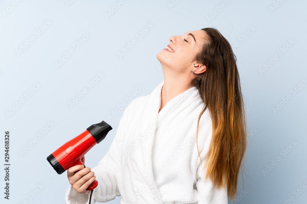 Young woman in a bathrobe with hair hairdryer Young woman in a bathrobe with hair hairdryer