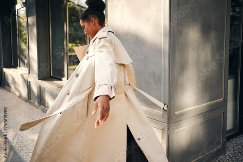 Tableau sur toile Back view of attractive casual African American girl in stylish trench coat drea