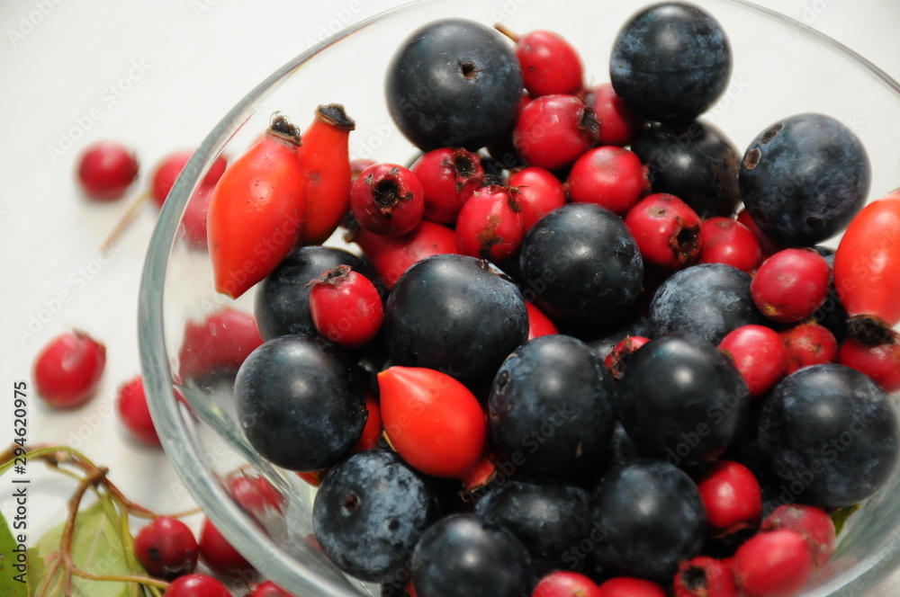 forest fruit in a glass bowl on a wooden table as decoration