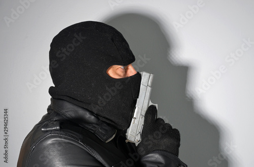 man in mask holding a pistol