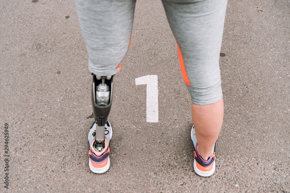 partial view of disabled sportswoman with prosthesis on street